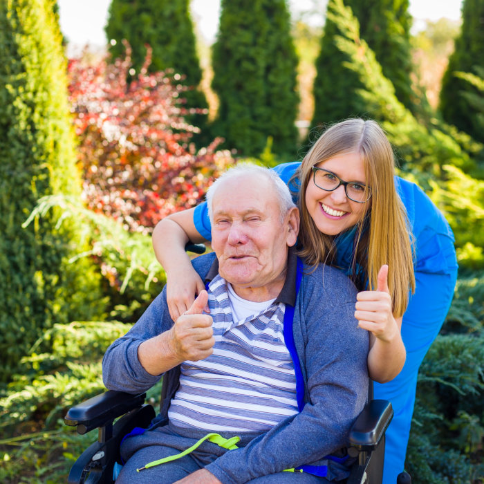 elderly man in wheelchair with his nurse